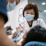 Dentist performing a dental cleaning on patient.
