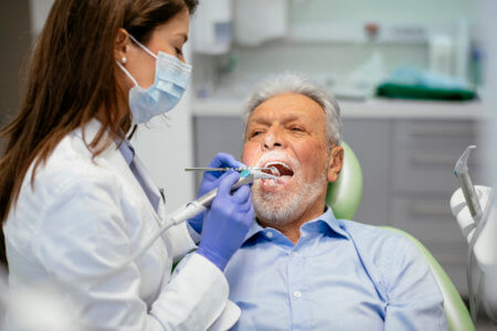 Dentist checking for discolored spots in patient's mouth