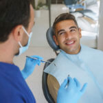Young man patient having dental treatment at dentist's office