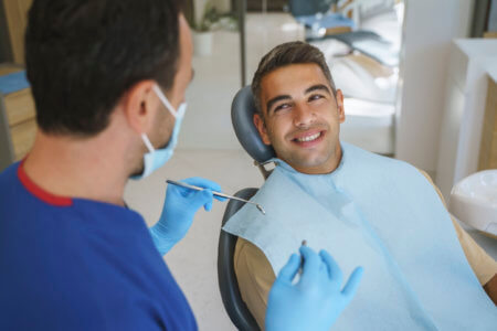 Young man patient having dental treatment at dentist's office